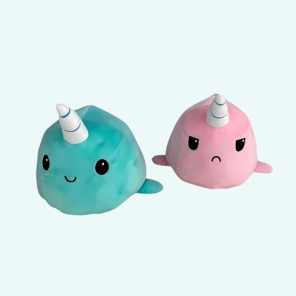 Green unicorn whale plush on a light blue background.