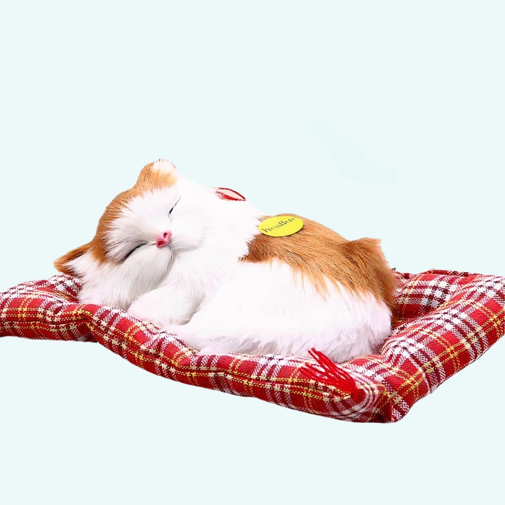 Cuddly toy cat red ans white sleeping on a light blue background.