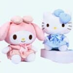 Hello Kitty plush in pink and blue uniform sitting on a book