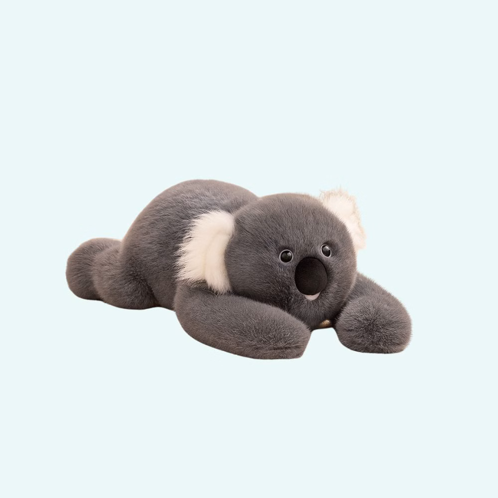 Img-Peluche_Lestee_Koala-1.Jpg Weighted plush in the shape of a koala with dark gray fur and white ears on a light blue background.