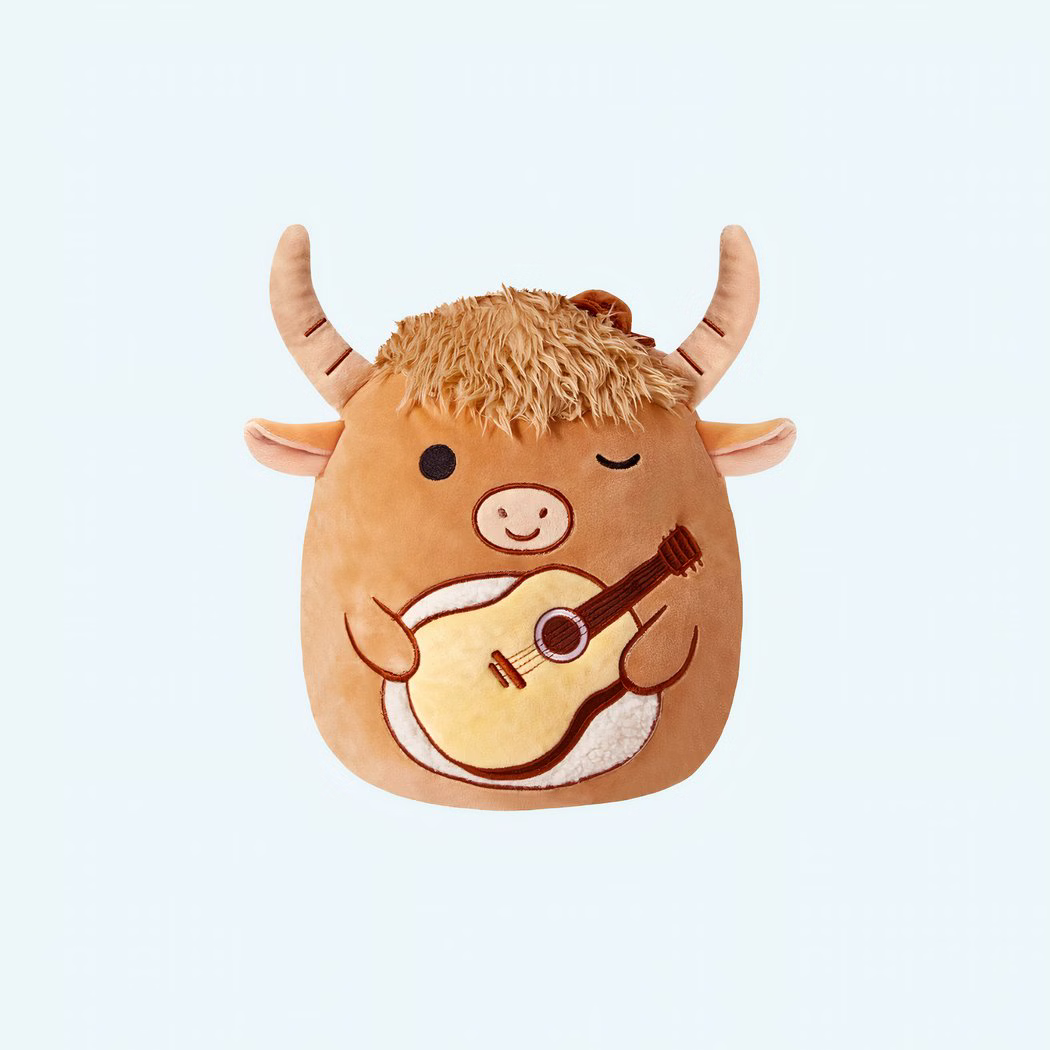 Img_01_25_Peluche_Squishmallow_Taureau_Guitare_1.Jpeg A Squishmallow bull plush with a guitar, front view on a light blue background