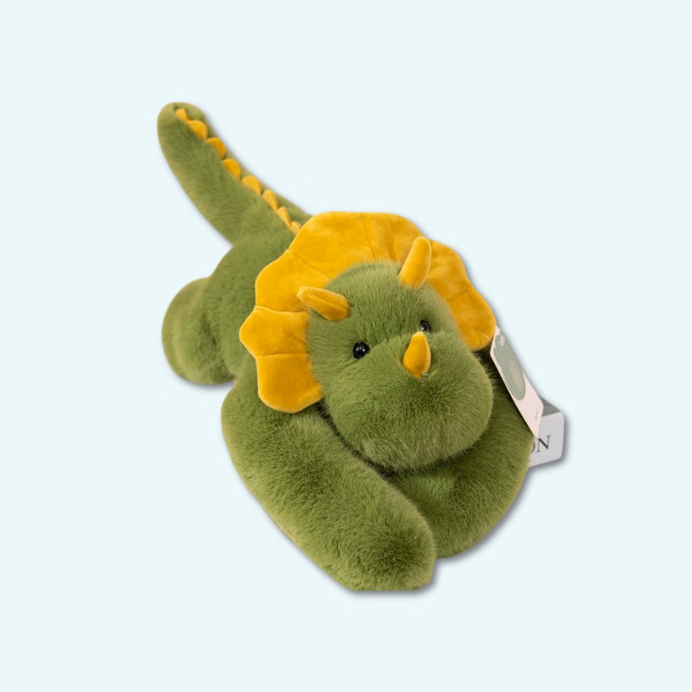Img_Peluche_Lestee_Dinosaure-1.Jpg Weighted plush shaped like a green and yellow dinosaur, on a sky blue background.